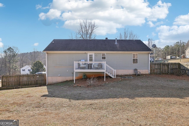 back of house featuring a lawn and a deck