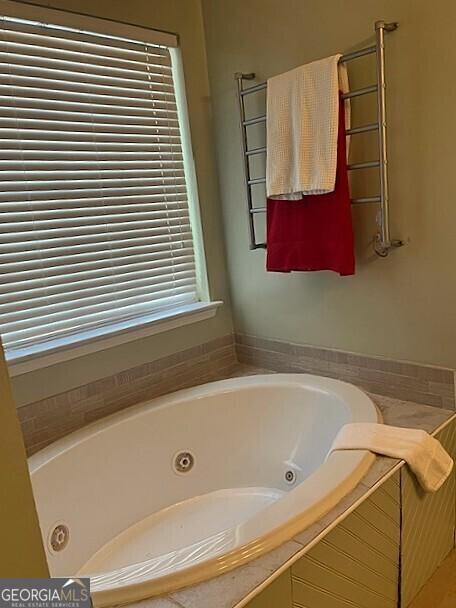 bathroom with a relaxing tiled tub