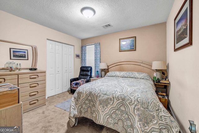 bedroom with light colored carpet, a closet, and a textured ceiling