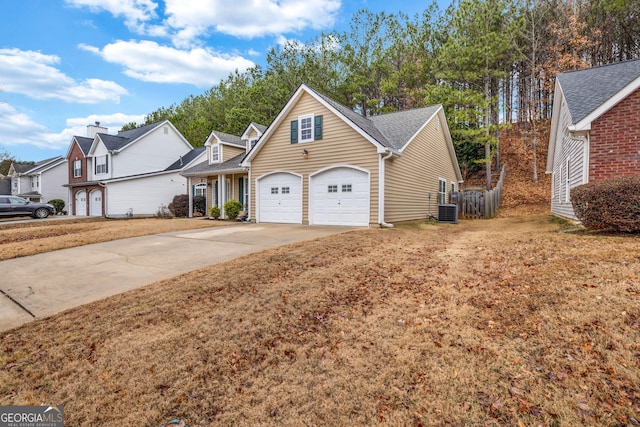 view of front of home featuring a garage, a front lawn, and central air condition unit