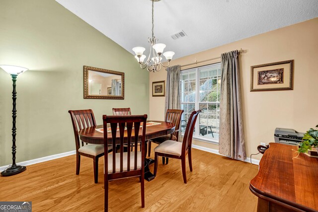 dining space with an inviting chandelier and light hardwood / wood-style flooring