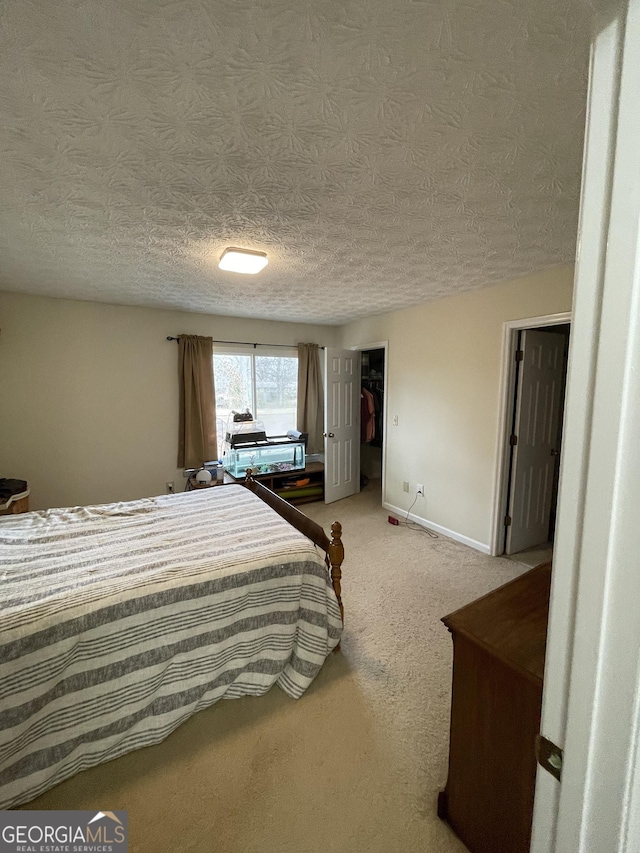 carpeted bedroom with a textured ceiling and a closet