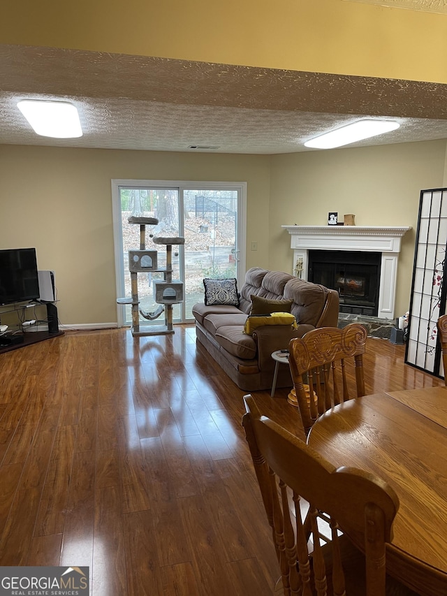 living room with wood-type flooring and a textured ceiling