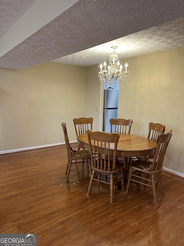 dining area with dark wood-type flooring and a textured ceiling