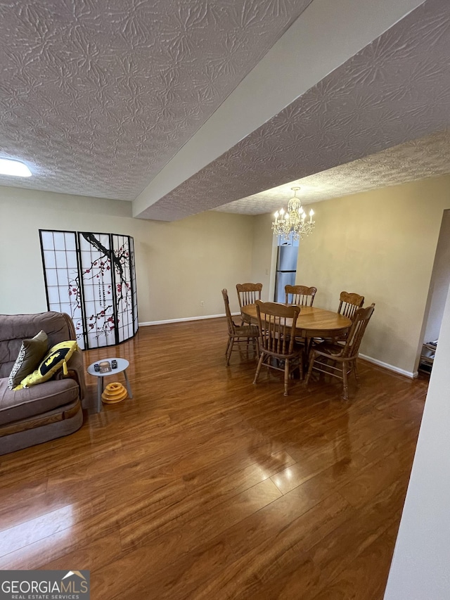 dining area with dark hardwood / wood-style flooring, a chandelier, and a textured ceiling