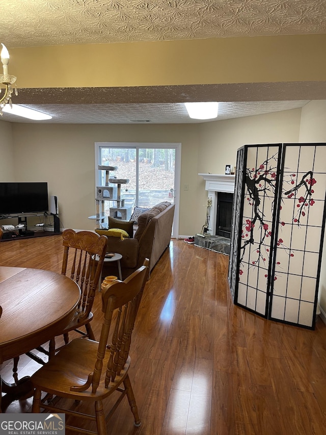 dining area with hardwood / wood-style floors and a textured ceiling