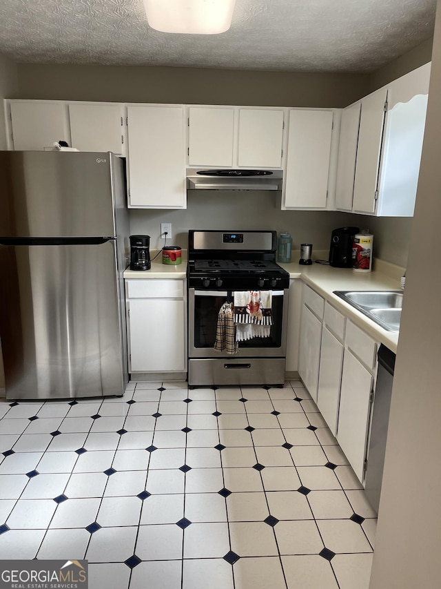 kitchen with white cabinetry, stainless steel appliances, sink, and a textured ceiling