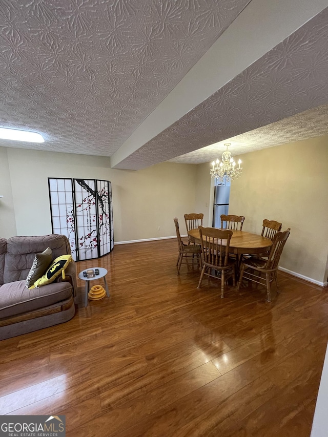 dining space with dark hardwood / wood-style floors, a textured ceiling, and a notable chandelier