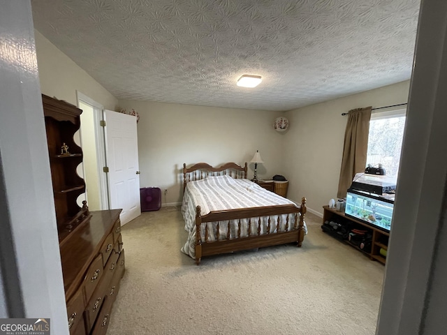 bedroom with light colored carpet and a textured ceiling