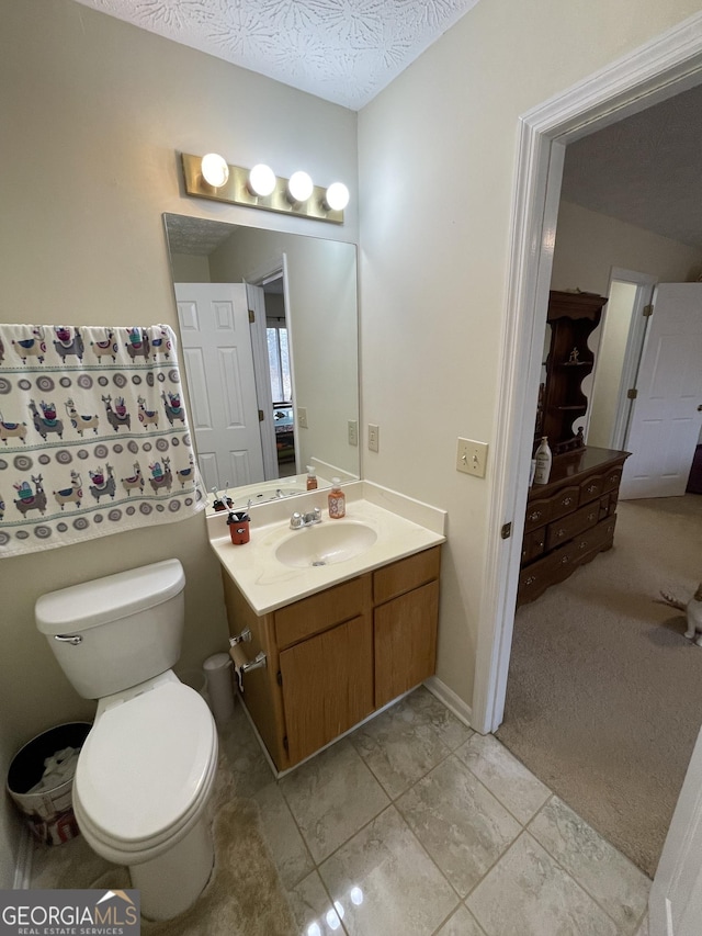 bathroom with vanity, a textured ceiling, and toilet