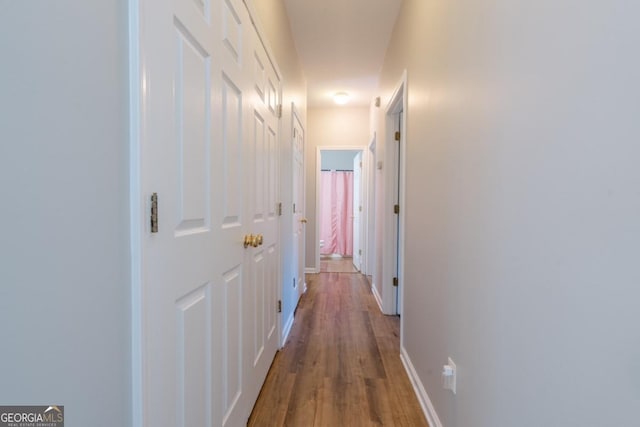 corridor with hardwood / wood-style flooring