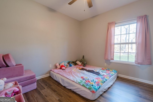 bedroom featuring multiple windows, dark hardwood / wood-style floors, and ceiling fan