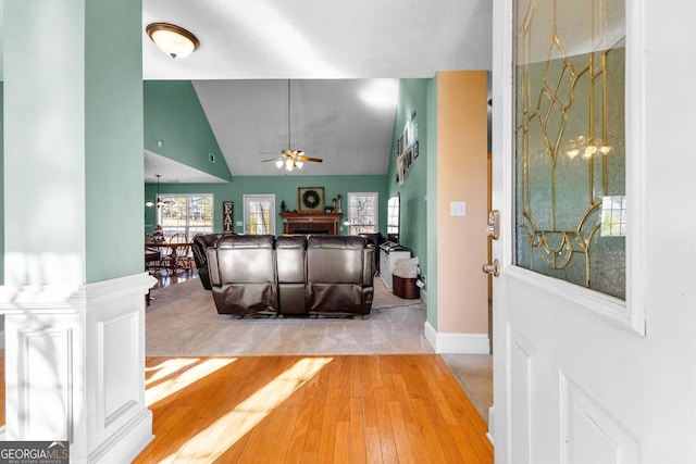 living room featuring hardwood / wood-style flooring, vaulted ceiling, and ceiling fan