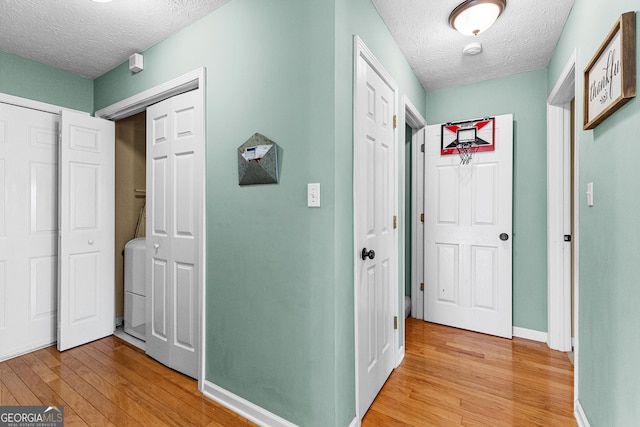 hallway featuring a textured ceiling and light wood-type flooring