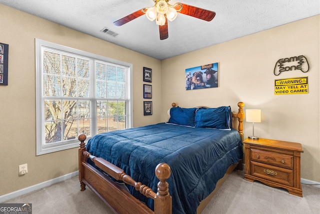 carpeted bedroom featuring a textured ceiling and ceiling fan