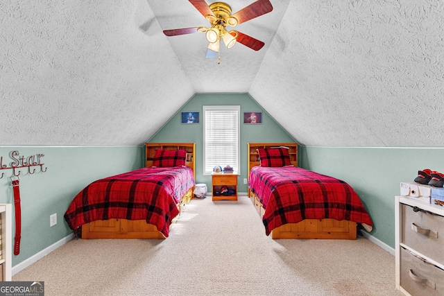 bedroom featuring ceiling fan, carpet flooring, vaulted ceiling, and a textured ceiling