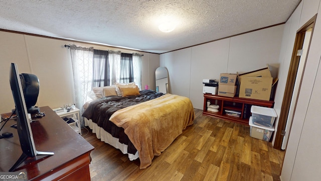 231 Canady Bridge Rd, Twin City, GA 30471 - bedroom with crown molding, wood finished floors, a textured ceiling, and a decorative wall
