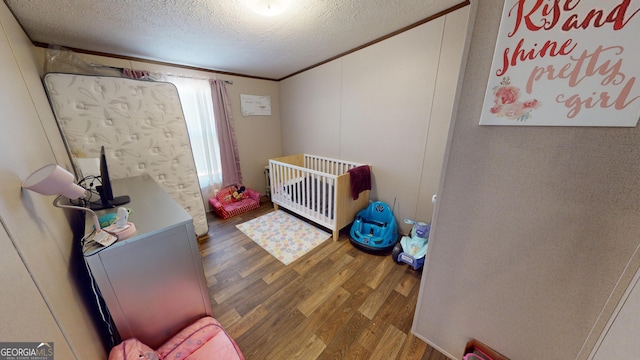 231 Canady Bridge Rd, Twin City, GA 30471 - bedroom featuring wood finished floors, a textured ceiling, and a crib