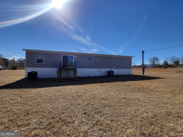 231 Canady Bridge Rd, Twin City, GA 30471 - rear view of house featuring entry steps, a yard, and central AC