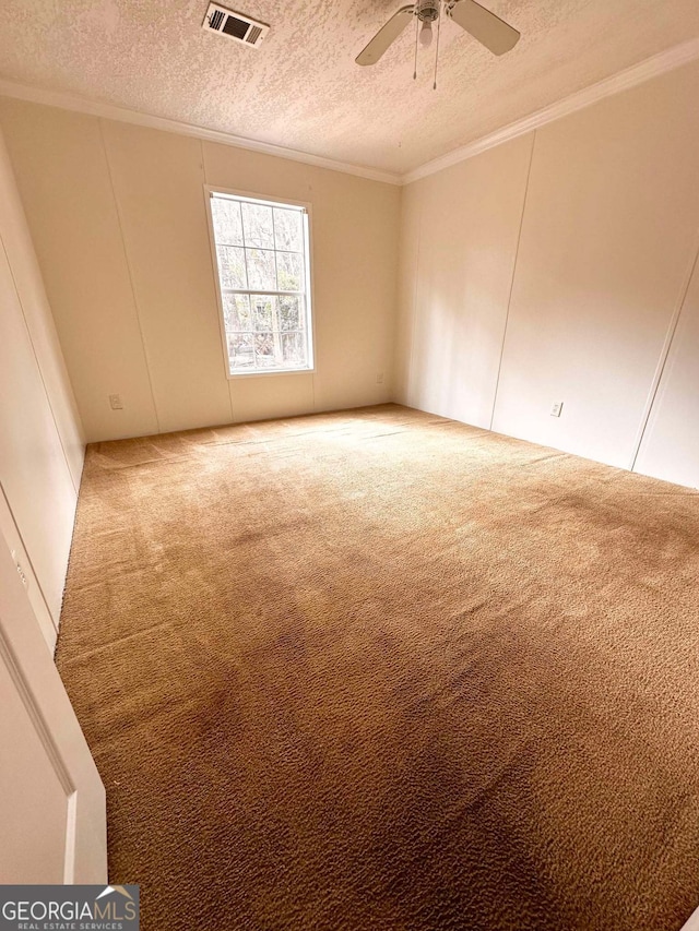 unfurnished room featuring crown molding, carpet, ceiling fan, and a textured ceiling