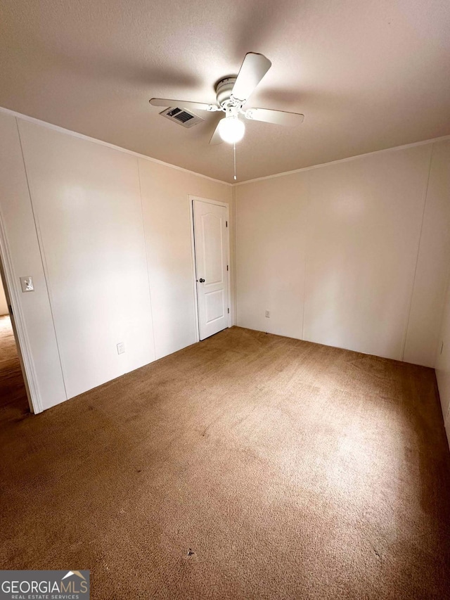 unfurnished room with ceiling fan and dark carpet