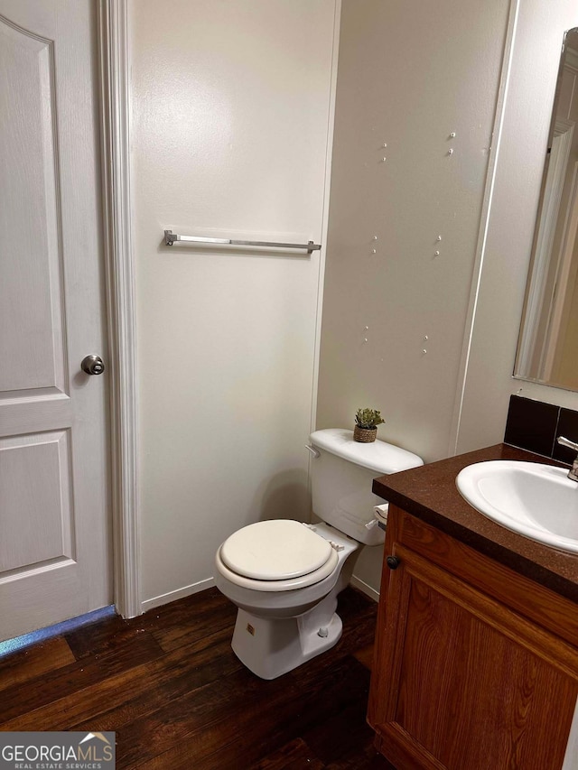 bathroom featuring vanity, hardwood / wood-style floors, and toilet