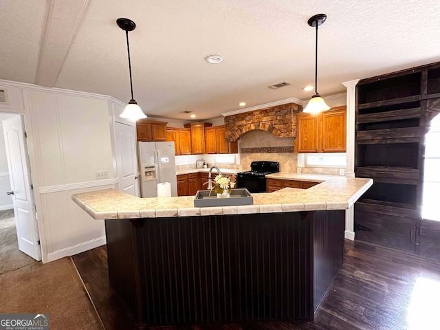 kitchen featuring a breakfast bar, sink, hanging light fixtures, black range with electric cooktop, and white refrigerator with ice dispenser