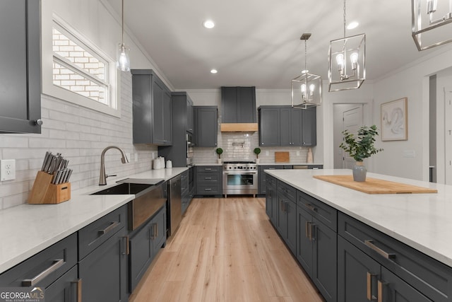 kitchen with sink, crown molding, appliances with stainless steel finishes, light hardwood / wood-style floors, and decorative light fixtures