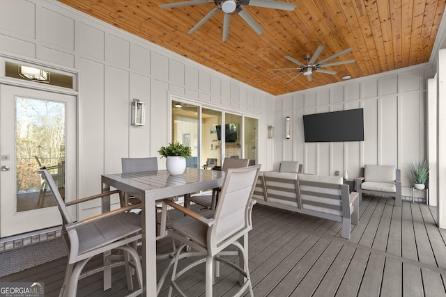 wooden terrace with ceiling fan and an outdoor living space