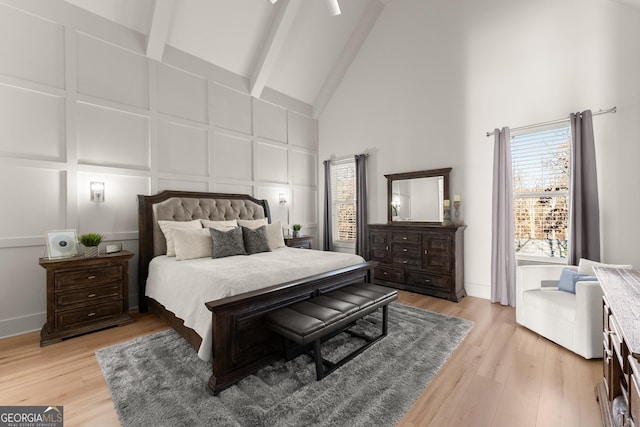 bedroom featuring high vaulted ceiling, beam ceiling, and light hardwood / wood-style floors