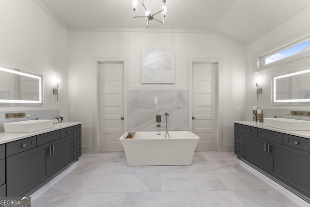 bathroom featuring ornamental molding, a bath, vanity, and a chandelier