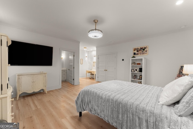 bedroom featuring ensuite bathroom and light wood-type flooring