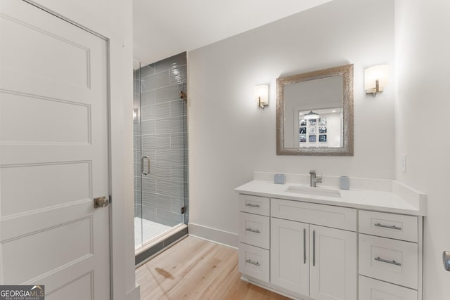 bathroom featuring a shower with door, vanity, and hardwood / wood-style floors