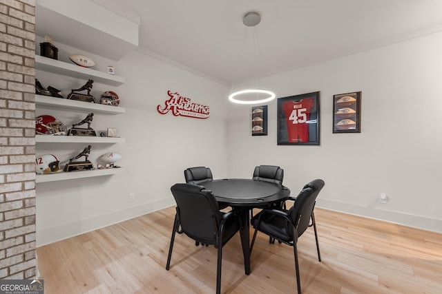 dining space featuring hardwood / wood-style flooring and ornamental molding