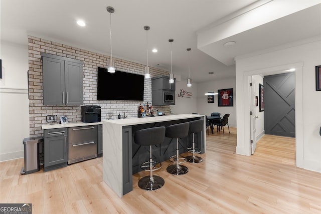 kitchen featuring a kitchen island, gray cabinetry, pendant lighting, and a kitchen breakfast bar