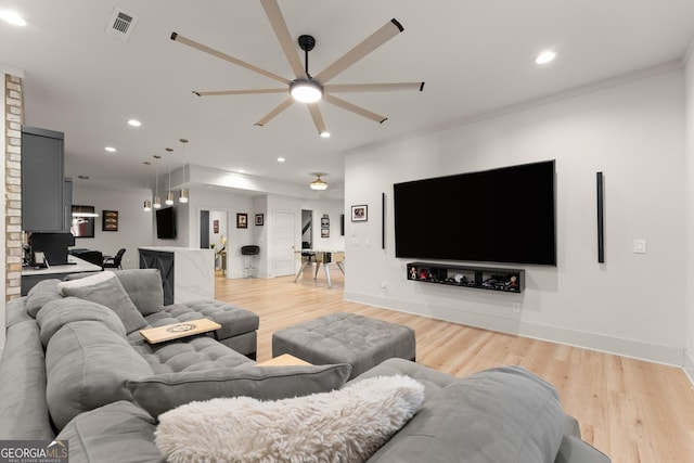 living room with ceiling fan and light hardwood / wood-style flooring