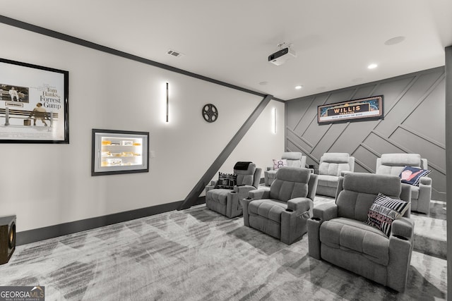 carpeted home theater room with crown molding