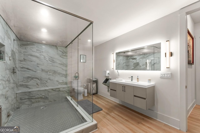 bathroom with vanity, an enclosed shower, hardwood / wood-style flooring, and toilet