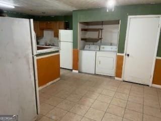 kitchen featuring washer and dryer and white fridge