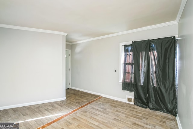 spare room with ornamental molding and light wood-type flooring