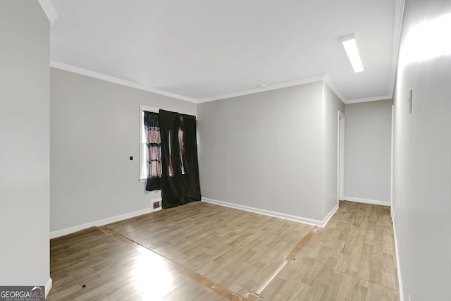 empty room featuring ornamental molding and light hardwood / wood-style flooring