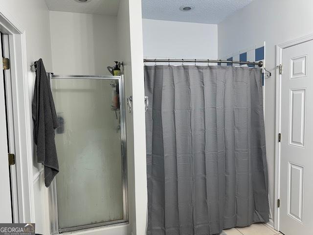 bathroom with a textured ceiling and walk in shower