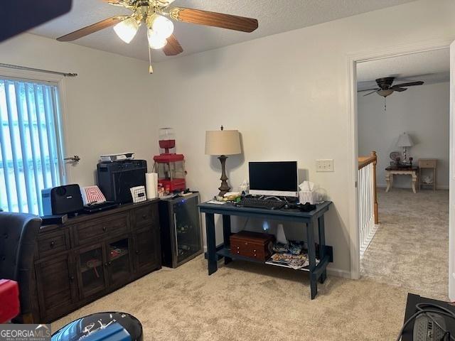 carpeted office space with ceiling fan