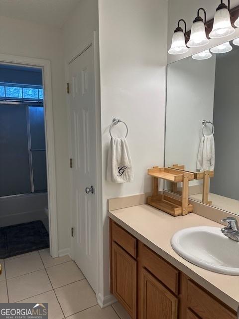 bathroom featuring tile patterned flooring, vanity, a chandelier, and shower / bathing tub combination