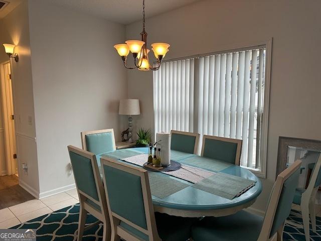 tiled dining space featuring a chandelier