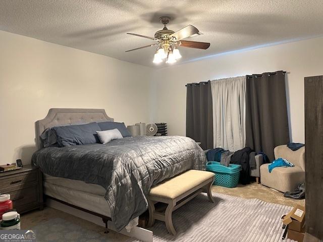 carpeted bedroom with ceiling fan and a textured ceiling