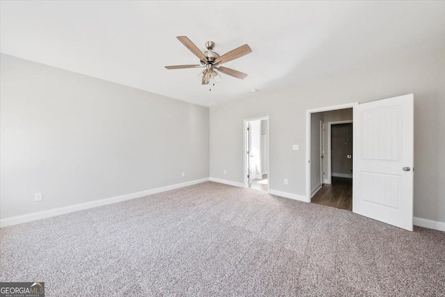 unfurnished bedroom with ceiling fan, connected bathroom, and dark carpet