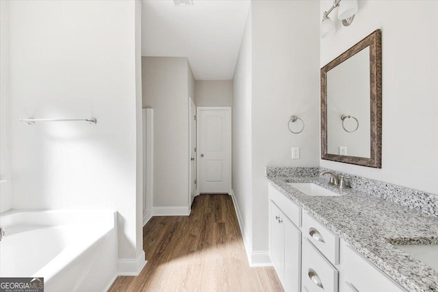 bathroom with vanity, a bathtub, and hardwood / wood-style floors