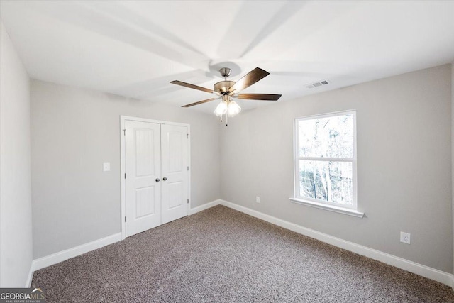 unfurnished bedroom featuring carpet flooring, ceiling fan, and a closet