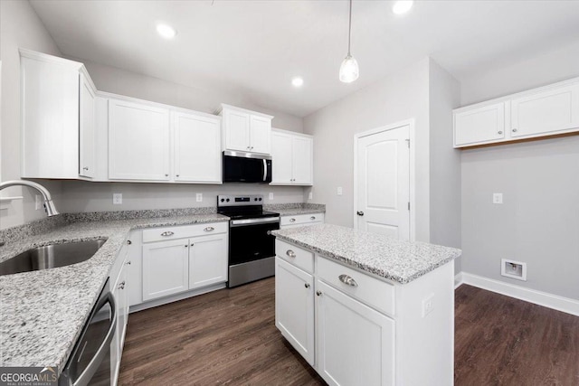 kitchen with sink, white cabinetry, decorative light fixtures, appliances with stainless steel finishes, and light stone countertops